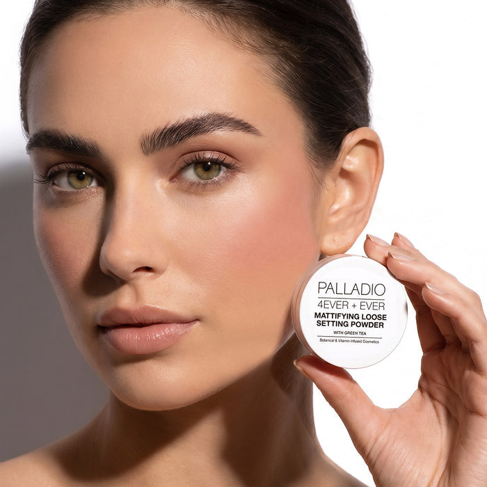 Model holding Palladio 4Ever + Ever Mattifying Loose Setting Powder with Green Tea beside her face.