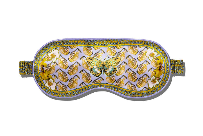 A slip silk sleep mask with a butterfly design, featuring gold and purple colors on a white background.