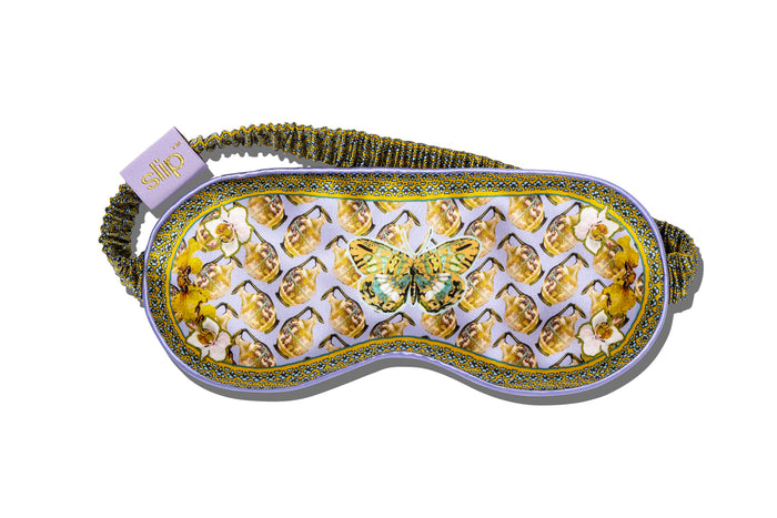 A colorful slip silk sleep mask with a zodiac Aquarius design, featuring yellow and purple tones and a butterfly motif.