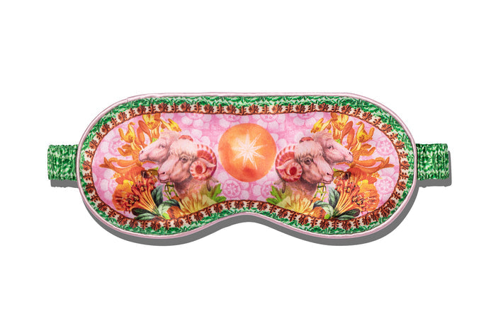 A slip silk sleep mask with a floral and ram design, featuring pink and green colors on a white background.