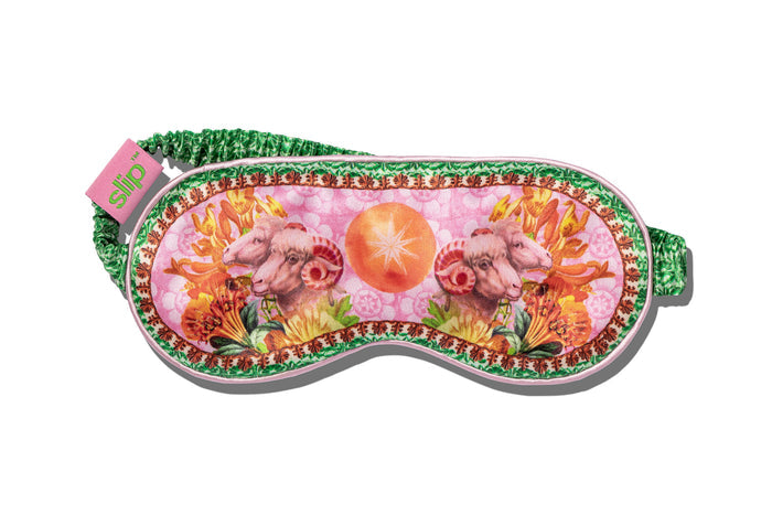 A colorful slip silk sleep mask with a zodiac Aries design, featuring pink and green tones and a floral motif.