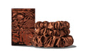A set of three auburn colored slipsilk scrunchies, including two midi and one large, stacked in front of branded packaging on a white background.