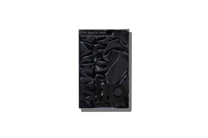 A set of three black slipsilk scrunchies, including two midi and one large, in branded packaging on a white background.