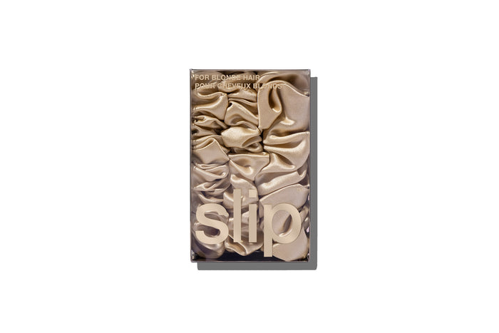 A set of three blonde slipsilk scrunchies, including two midi and one large, in branded packaging on a white background.