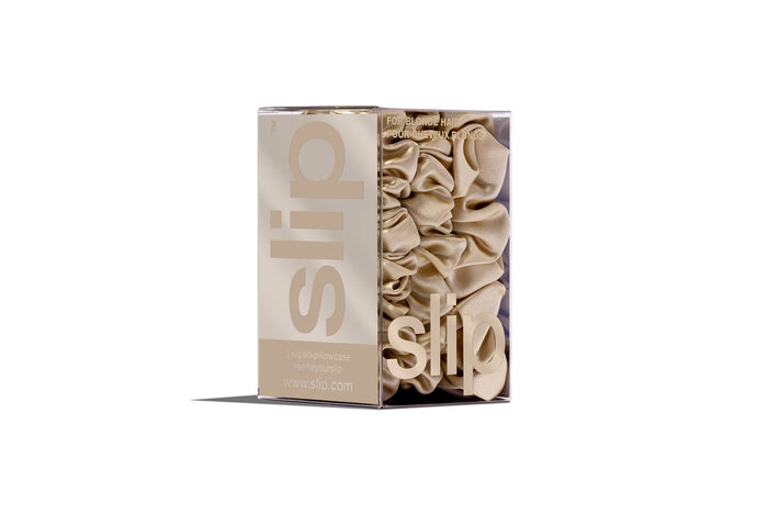 A set of three blonde slipsilk scrunchies, including two midi and one large, in branded packaging on a white background.