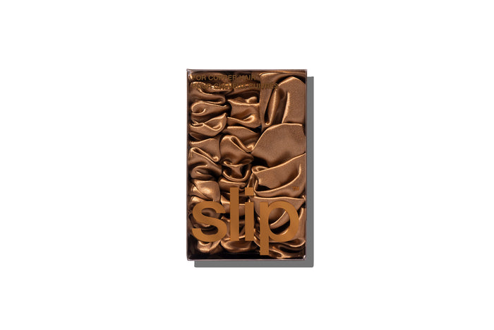 A set of three copper slipsilk scrunchies, including two midi and one large, in branded packaging on a white background.