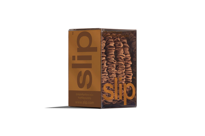 A set of four slip silk copper skinny scrunchies in branded packaging on a white background.