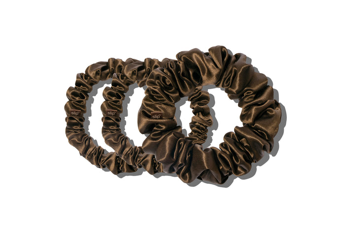 A set of three dark brown slipsilk scrunchies, including two midi and one large, on a white background.