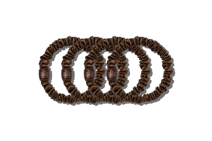 A set of four slip silk dark brown skinny scrunchies on a white background.