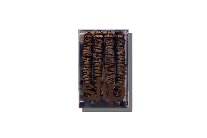 A set of four slip silk dark brown skinny scrunchies in branded packaging on a white background.