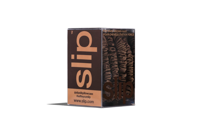 A set of four slip silk dark brown skinny scrunchies in branded packaging on a white background.