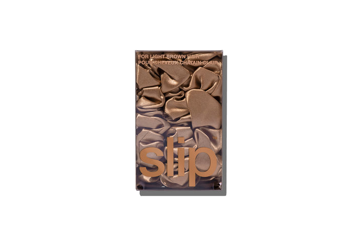 A set of three light brown slipsilk scrunchies, including two midi and one large, in branded packaging on a white background.