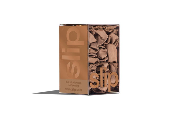 A set of three light brown slipsilk scrunchies, including two midi and one large, in branded packaging on a white background.