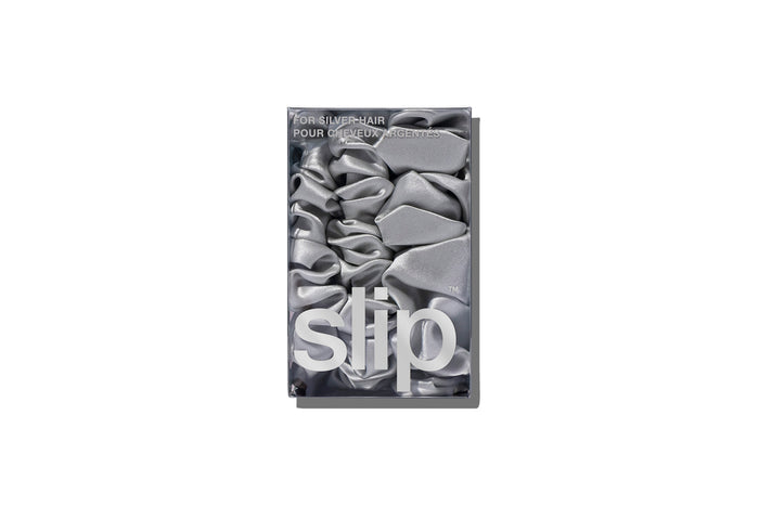A set of three silver slipsilk scrunchies, including two midi and one large, in branded packaging on a white background.