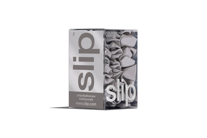 A set of three silver slipsilk scrunchies, including two midi and one large, in branded packaging on a white background.