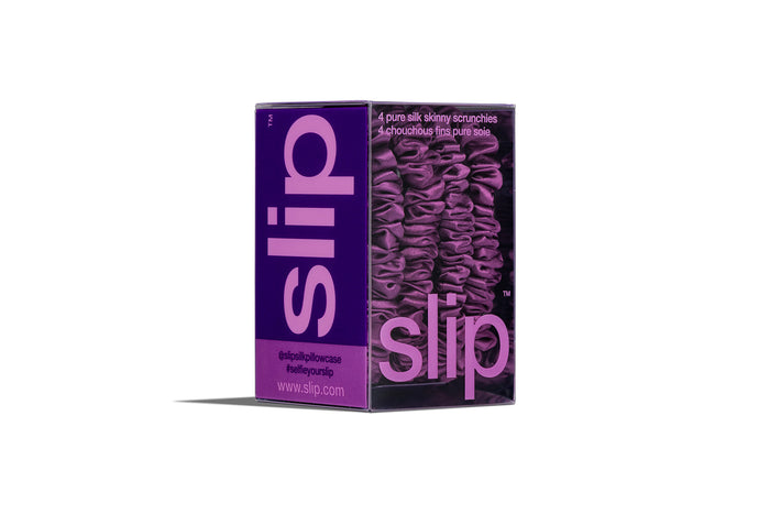Set of purple silk skinny scrunchies in slip packaging on a white background