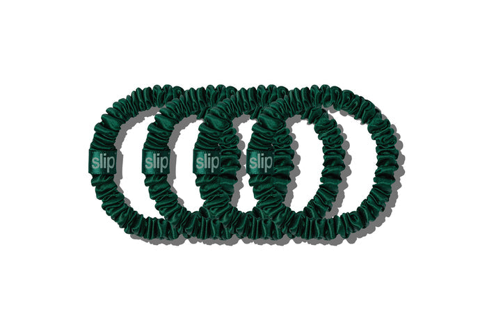 Set of four green slip skinny silk scrunchies on a white background