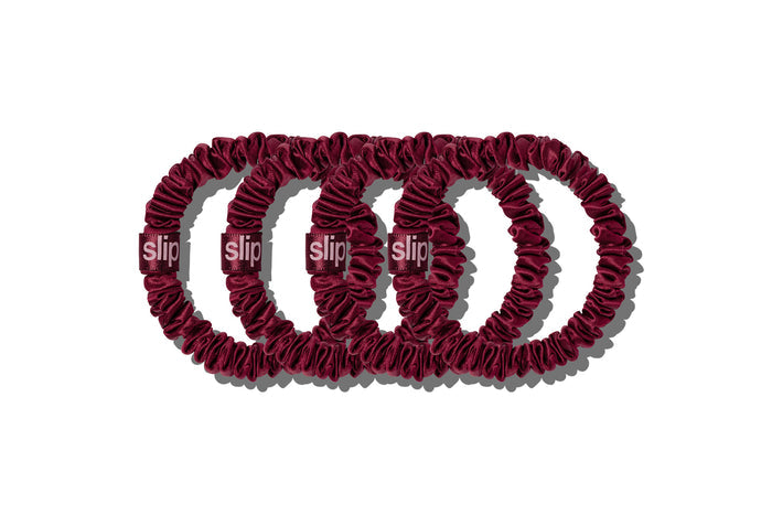 Four silk maroon skinny scrunchies on a white background