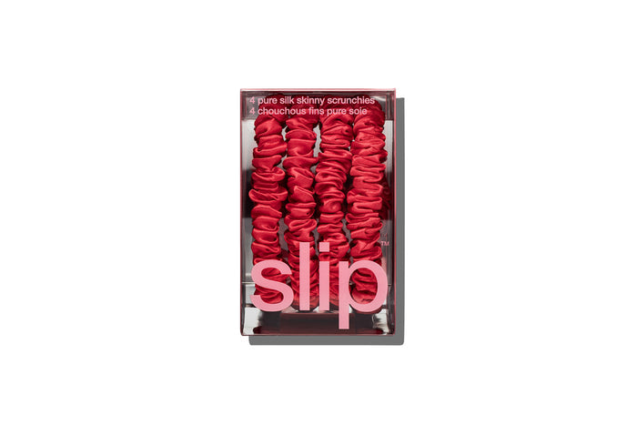 Set of red silk skinny scrunchies in slip packaging on a white background