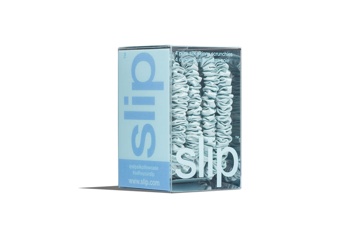 Sky blue scrunchies in slip packaging on a white background