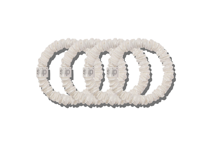 Four white silk skinny scrunchies on a white background