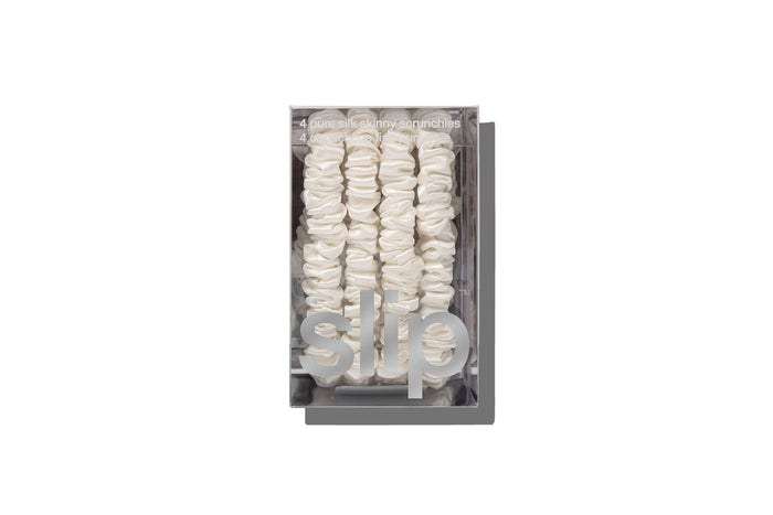 White silk skinny scrunchies in slip packaging on a white background.