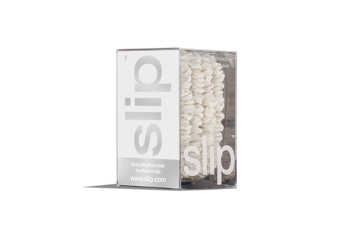 White silk skinny scrunchies in slip packaging on a white background.