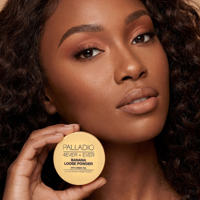 Model holding Palladio Banana Loose Setting Powder beside her face.