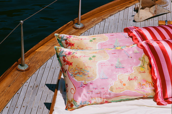 Colourful map graphic Slip silk pillowcases stacked on a boat.