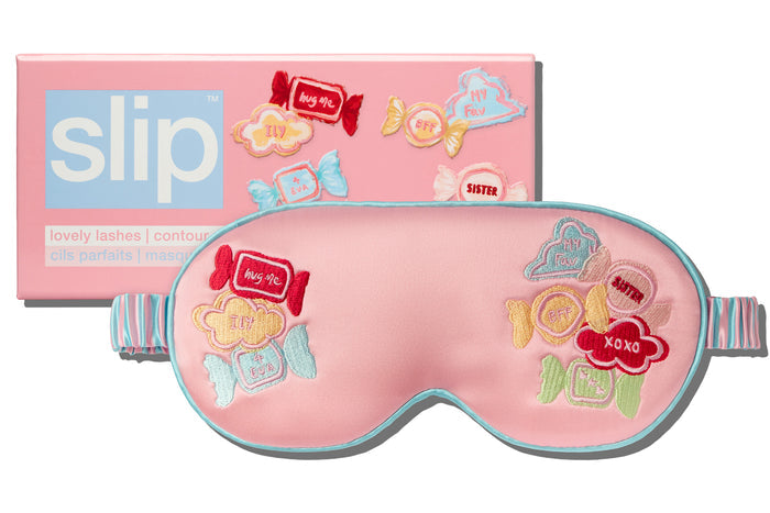Pink sleep mask with candy-themed embroidery design and 'slip' packaging