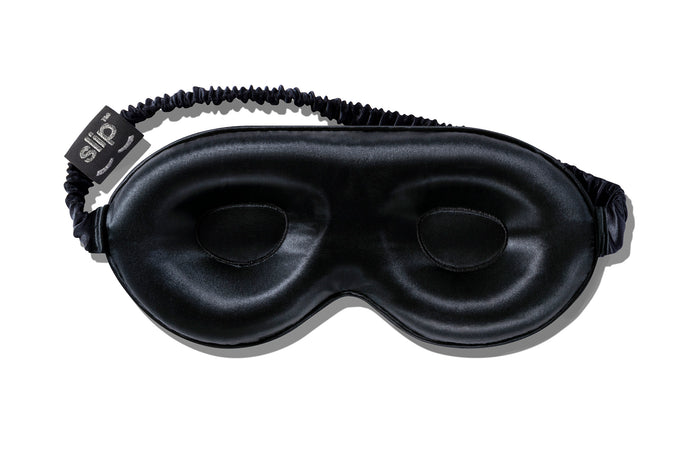 A black slip silk contour sleep mask on  on a white background. Designed to protect delicate eyelash extensions.