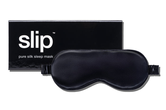 A black slip silk sleep mask with branded box on a white background.