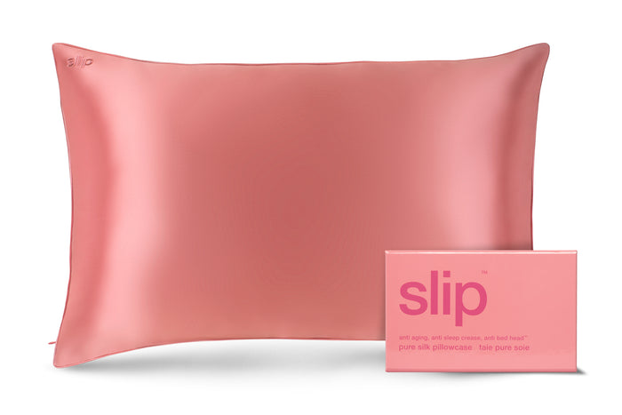 A blush pink queen-sized pillowcase with a zipper, displayed alongside its packaging box with the brand 'slip' visible.