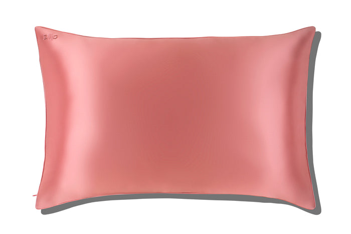 A blush pink queen-sized zippered pillowcase with piping and an invisible zipper closure.
