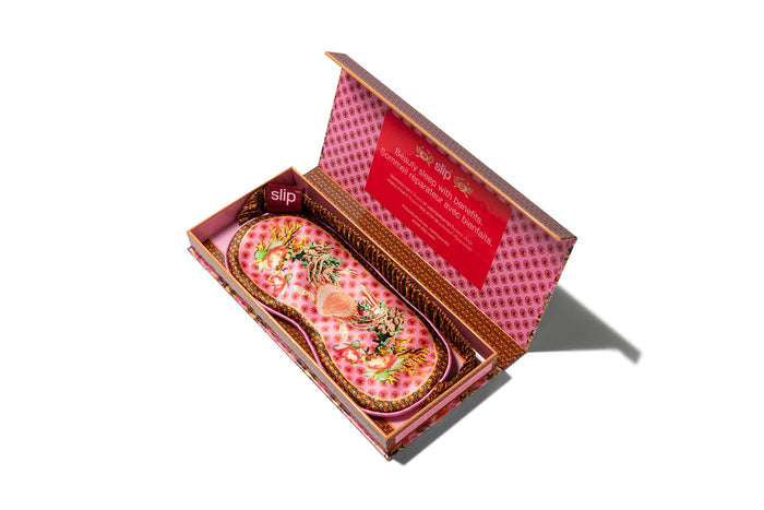A floral patterned slip silk sleep mask with Cancer star sign details. Displayed in a matching branded open packaging box.