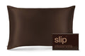 A dark brown slip silk pillowcase shown next to its matching dark brown packaging box with the brand name 'slip' printed in gold.