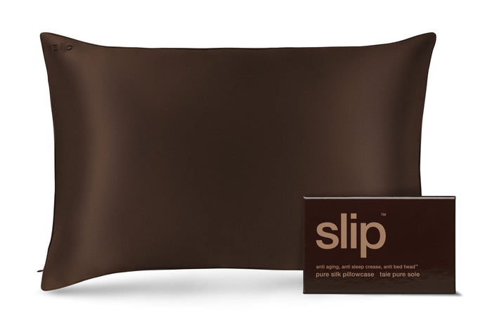 A dark brown slip silk pillowcase shown next to its matching dark brown packaging box with the brand name 'slip' printed in gold.
