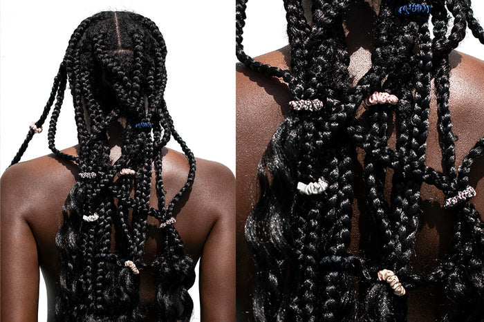 A woman with styled braided hair using six Slip silk minnie scrunchies in various colors including pink, caramel, silver, navy, leopard, and black.