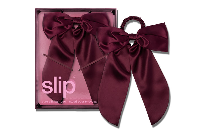 Burgundy Maroon Crimson silk hair bow with slip packaging on a white background.