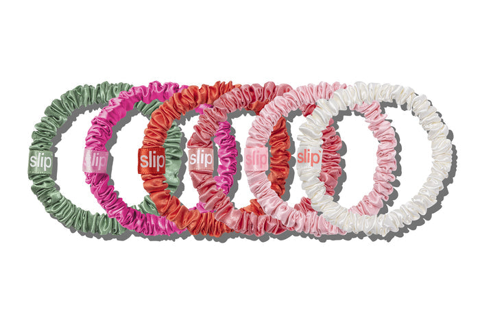 A collection of Slip brand skinny scrunchies in various colors including white, coral, peony, blush, candy, and pistachio.