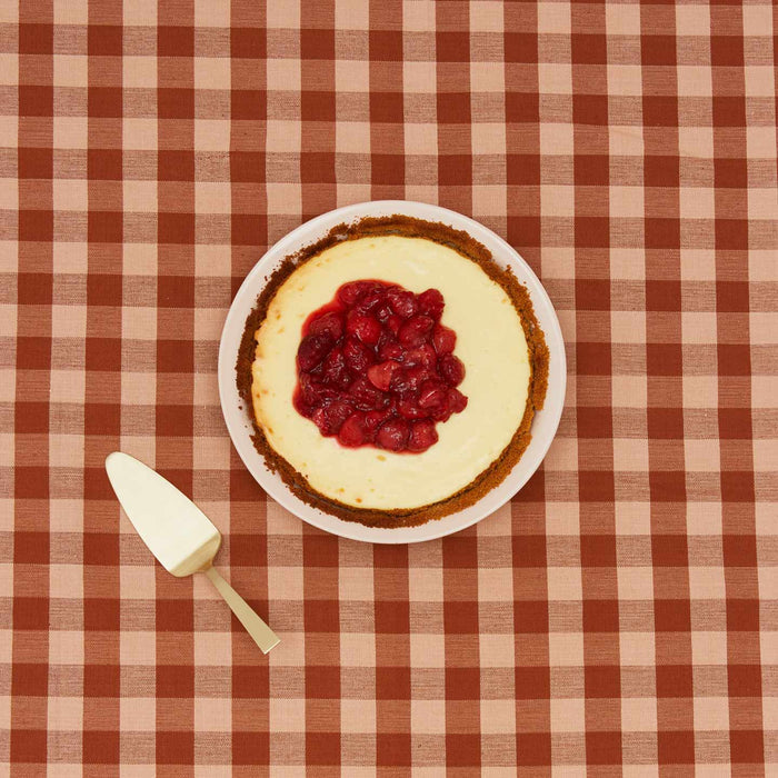 Essential pie dish with cheesecake on gingham background