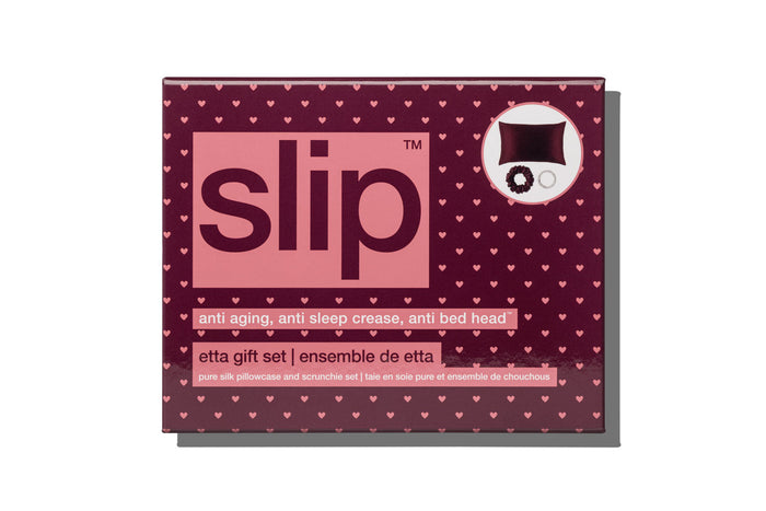 Slip brand 'etta gift set' packaging box, featuring a dark burgundy background patterned with small pink hearts, a large pink central panel with the brand name 'slip' in dark burgundy, and a white circular inset showing the included bedding items.
