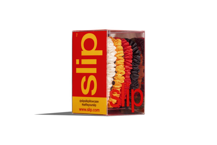Four colorful hair ties in a slip® branded box on a white background
