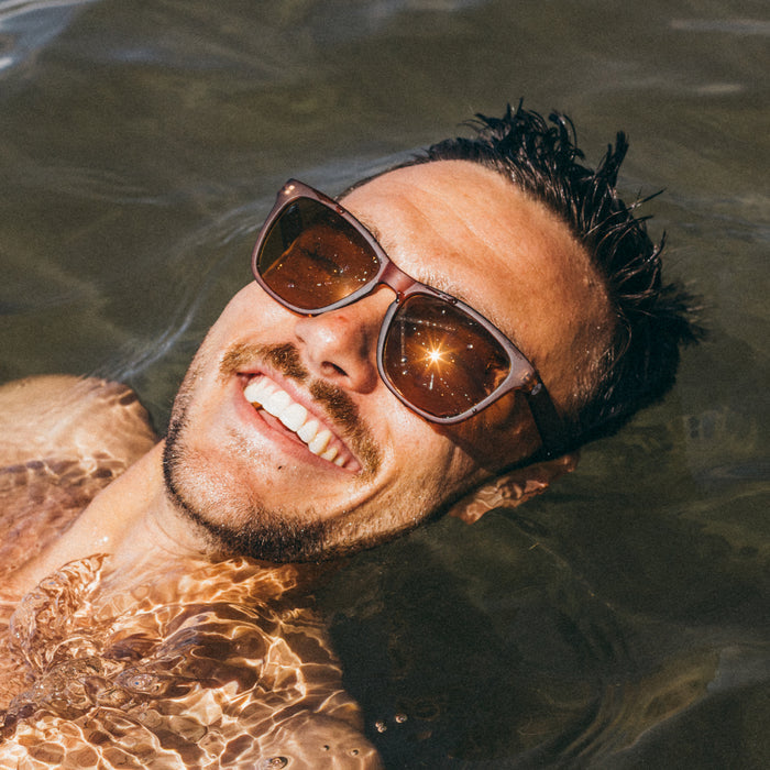 Man wearing sunglasses floating in water
