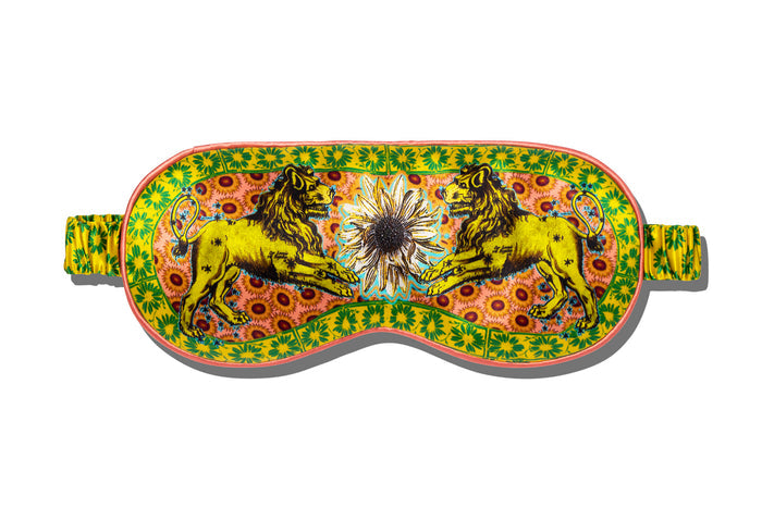A colorful slip silk sleep mask with a zodiac Leo design, featuring yellow and gold tones.