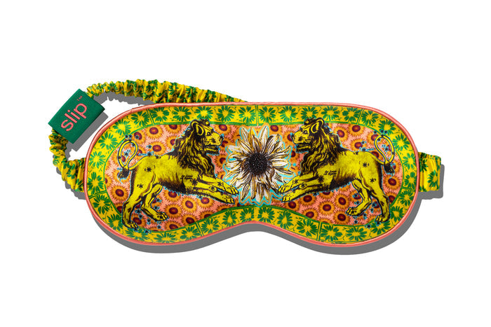 A colorful slip silk sleep mask with a zodiac Leo design, featuring yellow and gold tones.