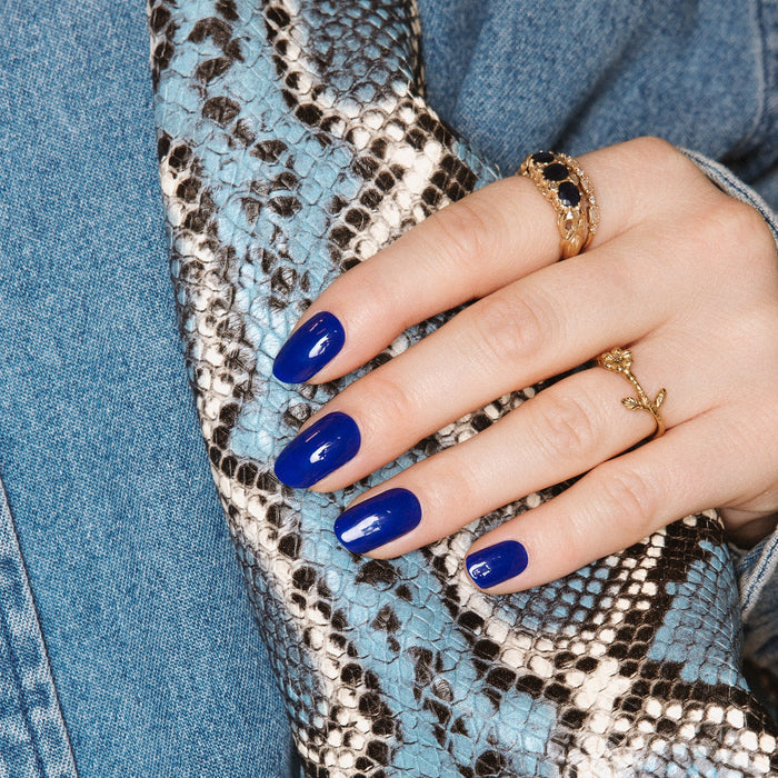 Maxima Blue Maniac nails royal blue gel stickers on hand with jeans and snake skin