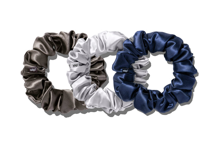 A set of three slip silk large scrunchies in navy, silver, and charcoal on a white background.