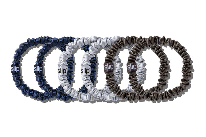A set of six slip silk skinny scrunchies in navy, silver, and charcoal on a white background.