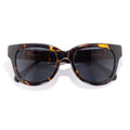Sunglasses with tortoiseshell frame and dark lenses on a white background